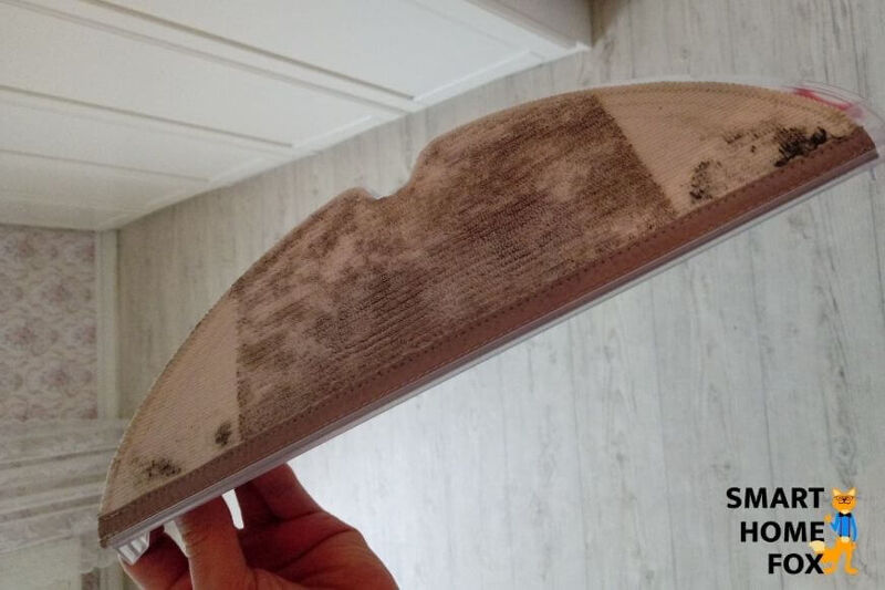 Dreckiger Wischmopp eines Saug-Wisch-Roboters wird in den Händen gehalten